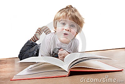 Boy pulling a funny face whilst reading book