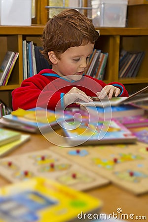 Boy reading books in a library