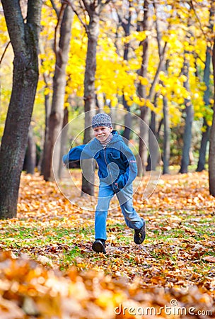 Boy runs in autumn park