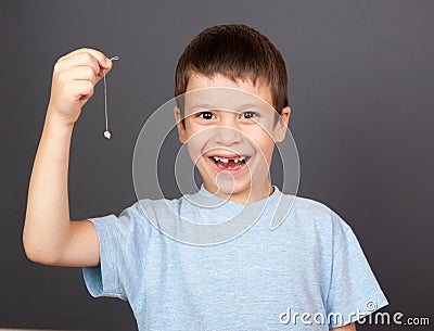 Boy show lost tooth on a thread