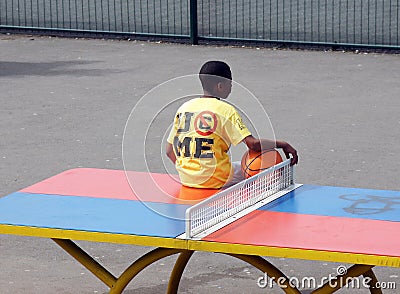 Boy sits on a table tennis table