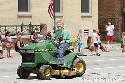 Boy on small tractor in a parade in small town America