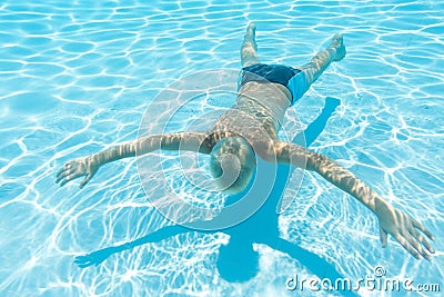 Boy swims under water face down