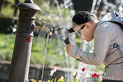 Boy taking photo - drinking water flowing from the faucet