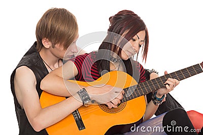 Boy teaches girl to play the guitar