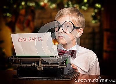 Boy typing a letter to Santa Claus on the typewriter