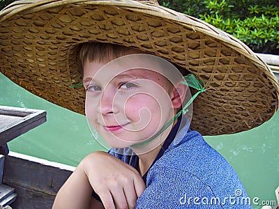 Boy wearing a hat out of palmtrees