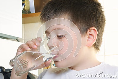 Boy in white drinks water