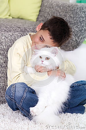 Boy with a white Persian cat at home