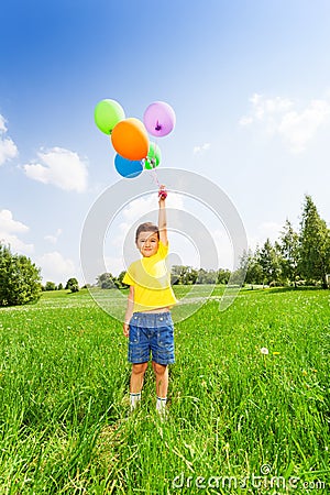 Boy in yellow T-shirt standing with balloons