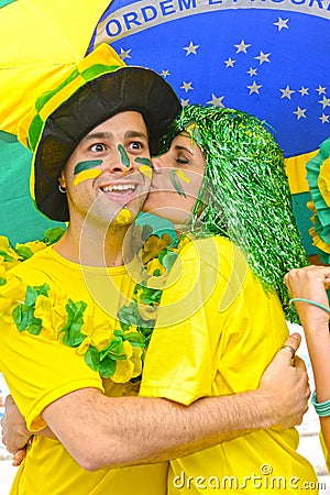 Brazilian woman soccer fans commemorating victory kissing.