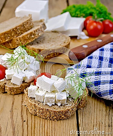 Bread with feta and tomatoes on board with knife