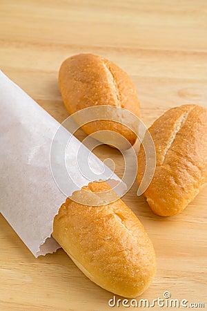 Bread in paper bag on wooden background