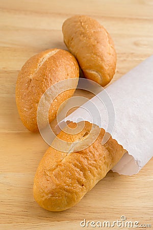 Bread in the paper bag on wooden table