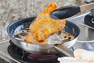 Breaded pork fried rice on a gas stove