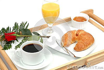 Breakfast tray with coffee, orange, juice, croissant, marmalade and 