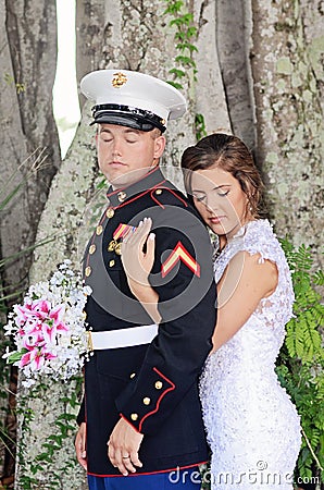 Bride with arms around military groom