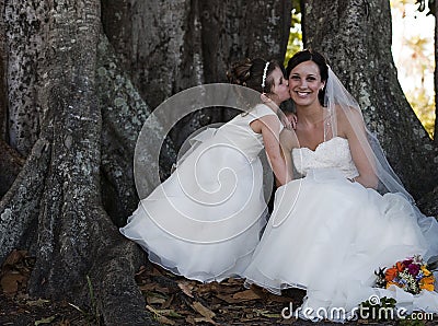 Bride and flower girl under tree