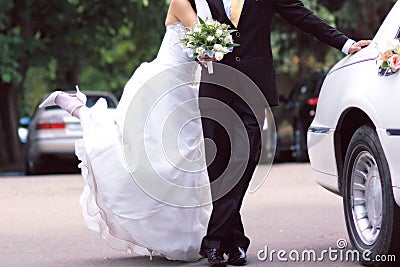 Bride and groom near limousine