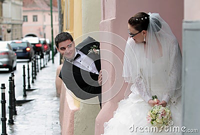 Bride and groom playing hide and seek