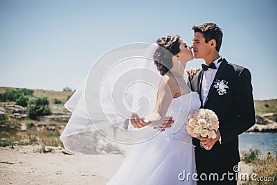 Bride and groom posing on the background of ancient ruins