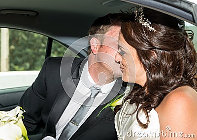 Bride and Groom in wedding car kissing