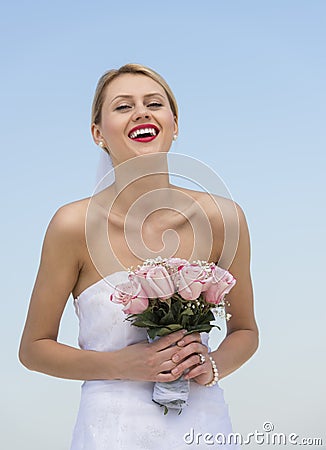 Bride Holding Flower Bouquet Against Clear Blue Sky