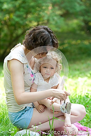 Bride mother is puts baby shoes on