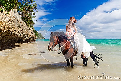 Bride walking with horse on a tropical beach