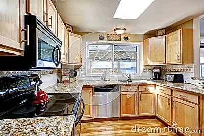 Bright kitchen with granite tops and black appliances