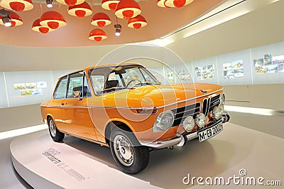 Bright orange BMW 2002 TI classic car on display in BMW Museum