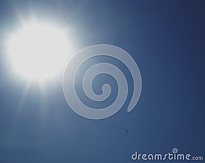 The bright sun with beams in the blue sky