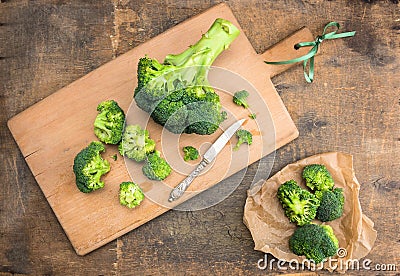 Broccoli cabbage on cutting board with vintage knife and crumpled paper