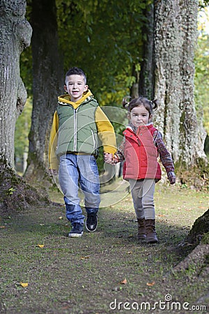 Brother and sister walking in the woods