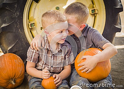 Brothers Sitting Against Tractor Tire Holding Pumpkins Whisperin