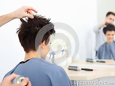 Brown Hair. The Hairdresser doing Hairstyle in Hair Salon.