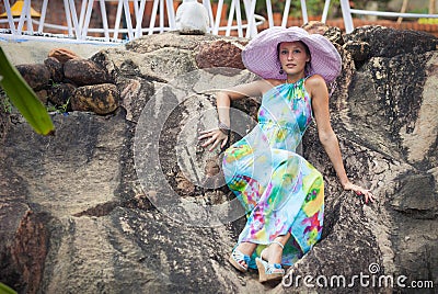 Brunette girl in flower dress and pink hat