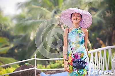 Brunette girl in flower dress and pink hat
