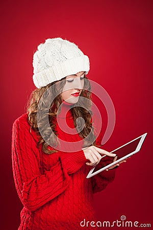Brunette girl holding ipad touchs screen searing internet