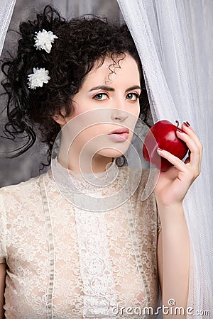 Brunette model in lace blouse holding apple