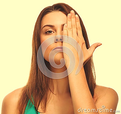 Brunette woman girl covered her face half hand isolated on white