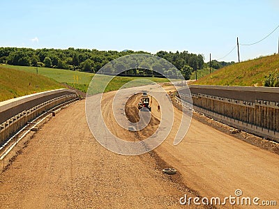 Building of new highway, scraper modify surface or gravel. Man in shorts is going.