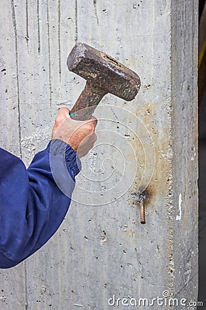 Building worker worker working with big hammer