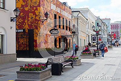 Buildings, flower beds, benches and walking people on Stoleshnik