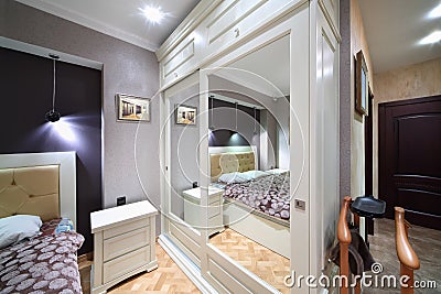 Built-in white wardrobe with mirrored doors in bedroom