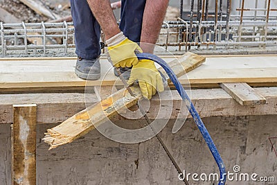 Bulder worker sawing wood board with hand saw