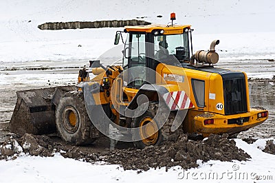 Bull dozer deep in mud and snow