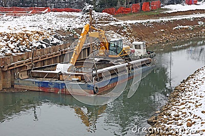 Bulldozer Digger in a barge during the work of the River