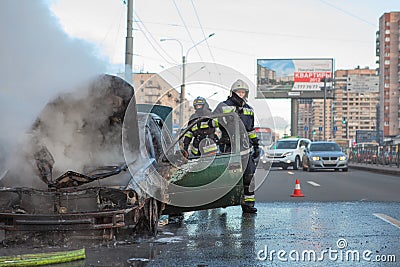 Burned car with smoke on city street