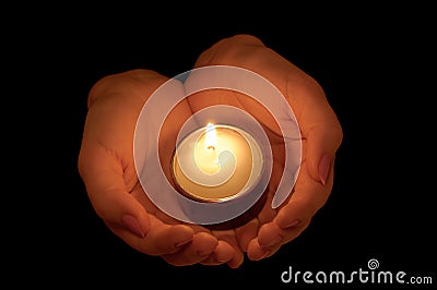 Burning candle in female hands